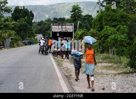 (210822) -- LES CAYES, 22 agosto 2021 (Xinhua) -- Foto scattata il 21 agosto 2021 mostra le persone che ricevono forniture di vita a Marceline, nei pressi di Les Cayes, Haiti. (Xinhua/David de la Paz) Foto Stock