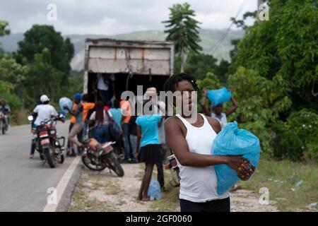 (210822) -- LES CAYES, 22 agosto 2021 (Xinhua) -- Foto scattata il 21 agosto 2021 mostra le persone che ricevono forniture di vita a Marceline, nei pressi di Les Cayes, Haiti. (Xinhua/David de la Paz) Foto Stock