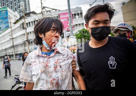 Bangkok, Bangkok, Thailandia. 22 agosto 2021. Un ragazzo di 15 anni è portato via per essere portato in ospedale dopo essere stato colpito in faccia con un proiettile di gomma. Per l'ottava notte consecutiva il quartiere DIN Daeng di Bangkok è stato teatro di intensi scontri. Informalmente allineati con il movimento di protesta pro-democrazia, iniziato nel luglio 2020, i gruppi di studenti professionali hanno sempre più agitato i confronti con la polizia, Frustrati dal terribile impatto che la terza ondata di Covid -19 ha avuto sulla Thailandia e la percezione del governo di incompetenza nel gestire la crisi questi giovani non vedono altra opzione che t Foto Stock