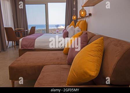 Soggiorno zona soggiorno nel lussuoso monolocale mostra casa con arredamento di design interno con balcone vista mare e letto matrimoniale Foto Stock