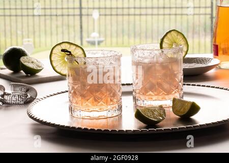 Primo piano di due mocktail margarita illuminati da dietro, guarniti con fettine di lime. Foto Stock