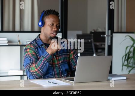 Giovane dipendente africano americano maschio parlare con webcam chiamata Foto Stock