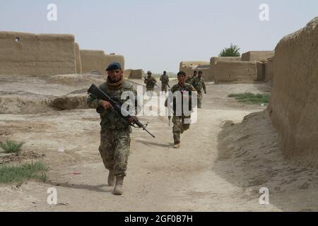 I soldati dell'esercito della nazione afghana assegnati al 1° Kandak, 2° Brigata, 203° corpo, di stanza alla base dell'esercito nazionale afghano, alla guarnigione di Khair Kut, nella provincia di Paktika, in Afghanistan, si muovono rapidamente attraverso il villaggio di Panagir, alla ricerca dei nemici dell'Afghanistan, 22 maggio 2013. La missione pianificata e guidata afghana faceva parte di un'operazione di sgombero progettata per catturare, uccidere o distruggere i nemici dell'Afghanistan che sono noti per usare le città del distretto di Kushamond come rifugi sicuri. (Foto di U.S. Army Sgt. Mark A. Moore II - 2/10 Brigata di assistenza delle forze di sicurezza) Foto Stock