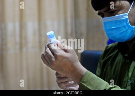 Un operatore sanitario si prepara ad inoculare con una seconda dose del vaccino Moderna COVID19 durante la campagna di vaccinazione di massa presso il centro di vaccinazione di shamoli a Dhaka, Bangladesh, il 22 agosto 2021. Foto Stock