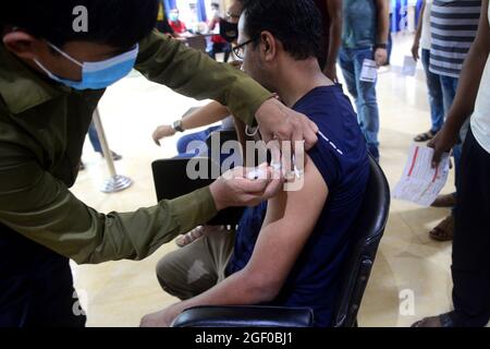 Una persona riceve una seconda dose del vaccino moderna COVID19 durante la vaccinazione di massa al centro di vaccinazione di shamoli a Dhaka, Bangladesh, 22 agosto 2021. Foto Stock