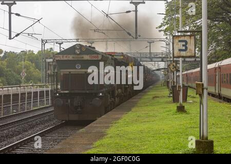 RO-Ro (Roll on Roll Off) treno che trasporta camion che attraversano alla stazione ferroviaria di Sawantwadi sulla ferrovia di Konkan, Maharashtra, India Foto Stock