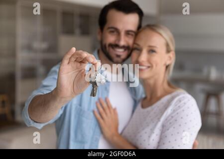 Felice coppia millenaria che mostra chiave da casa nuova Foto Stock