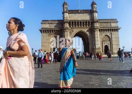 Mumbai, Maharashtra, India : le donne indiane camminano oltre l'arco monumentale Gateway of India costruito tra il 1913 e il 1924 in stile Indo-Saracenico. Foto Stock