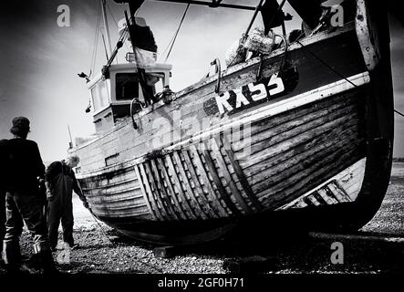 I pescatori di Hastings trasportano la loro barca sulla spiaggia, Sussex orientale, Inghilterra, Regno Unito Foto Stock
