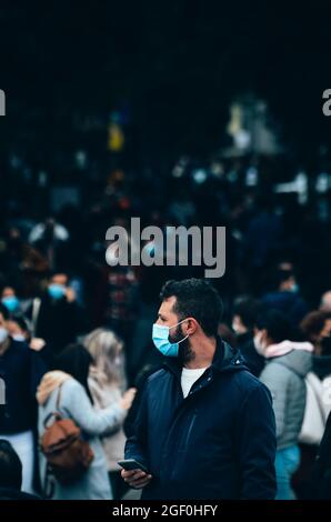 MADRID, SPAGNA - Nov 15, 2020: Un uomo che indossa una maschera tra la folla durante l'epidemia di Covid-19 catturato nel centro di Madrid Foto Stock