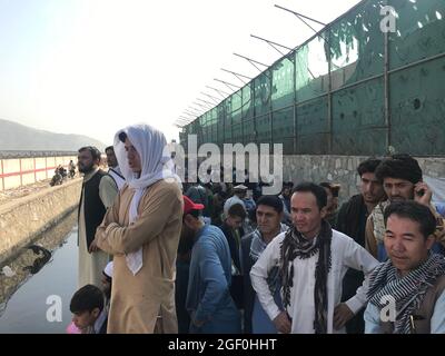 Kabul, Afghanistan. 22 agosto 2021. Gli afghani si riuniscono vicino ad una porta dell'aeroporto di Kabul, Afghanistan, 22 agosto 2021. Sette civili afghani sono stati uccisi in mezzo al caos vicino all'aeroporto di Kabul mentre la gente ha inghiottito la zona nella speranza di salire a bordo di un volo di evacuazione dopo l'acquisizione dei talebani dell'Afghanistan, ha detto domenica il Ministero della Difesa britannico. Credit: Rahmatullah Alizadah/Xinhua/Alamy Live News Foto Stock