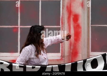 Una donna spruzza vernice rossa sull'esterno della Guildhall di Londra, durante una protesta dei membri della Rebellion dell'estinzione. Data foto: Domenica 22 agosto 2021. Foto Stock