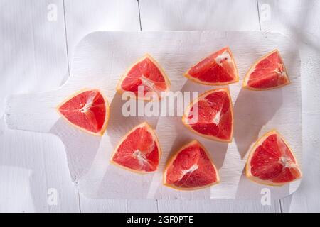 Presentazione sul rosso taglio Segmenti di pompelmi e di pomeli Foto Stock