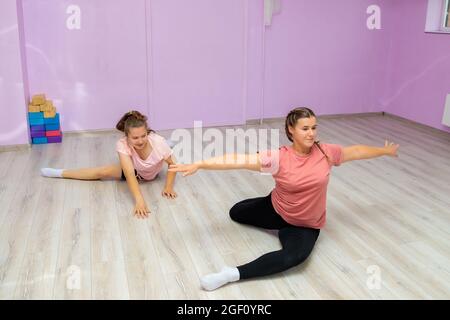 L'istruttore di danza della ragazza mostra gli elementi del numero ad un'altra ragazza. Allenamento di danza. Foto Stock