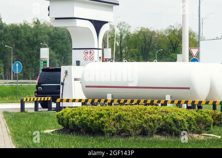 Stazione di gas propano liquido. Serbatoio di rifornimento SUV moderno nero con carburante liquefatto naturale a potenza alternativa Foto Stock