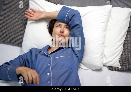 Donna in pigiama che ha mal di testa Foto Stock