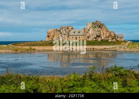 Una piccola casa Castel Meur tra le rocce vicino al mare in Plougrescant, Francia Foto Stock