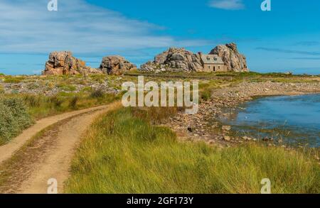 Un sentiero per una piccola casa Castel Meur tra le rocce vicino al mare in Plougrescant, Francia Foto Stock