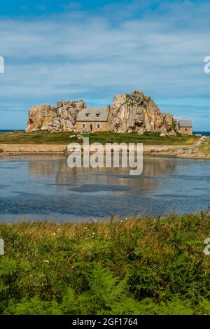 Un colpo verticale di piccola casa Castel Meur tra le rocce vicino al mare in Plougrescant, Francia Foto Stock