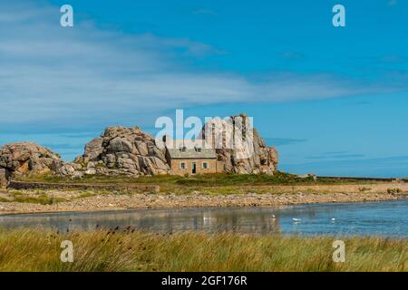 Una piccola casa Castel Meur tra le rocce vicino al mare in Plougrescant, Francia Foto Stock