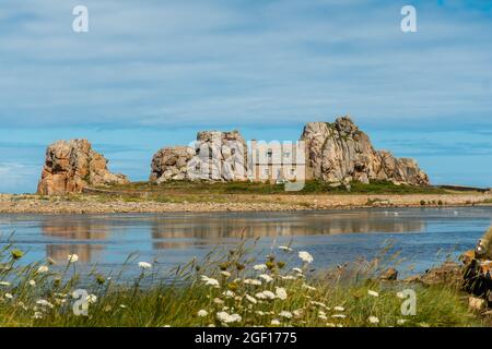 Una piccola casa Castel Meur tra le rocce vicino al mare in Plougrescant, Francia Foto Stock