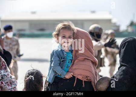 Kabul, Afghanistan. 21 Agosto 2021. Un bambino afghano sorride mentre esce per un volo di evacuazione all'aeroporto internazionale Hamid Karzai durante l'operazione Rifuge Allees 21 agosto 2021 a Kabul, Afghanistan. Credit: Planetpix/Alamy Live News Foto Stock