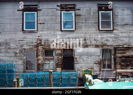 Un molo pieno di trappole di aragosta e un vecchio edificio, vecchio porto, a Portland, Maine. Foto Stock