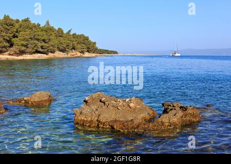 Uno yacht ormeggiato alla spiaggia di Zlatni Rat (spesso chiamata Capo d'Oro o Corno d'Oro) a Bol (Isola di Brac), Croazia Foto Stock