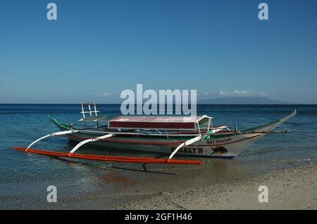 MINDORO, FILIPPINE - 12 gennaio 2007: Una barca da pesca parcheggiata sulla spiaggia sabbiosa, Mindoro, Filippine Foto Stock