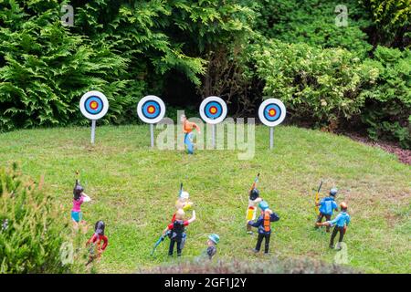 Primo piano di figurine modello in piedi sul prato giocando un gioco di tiro con l'arco Foto Stock