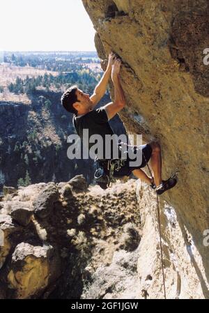 Un uomo rock climbing allo Smith Rock state Park in Oregon, USA. Foto Stock