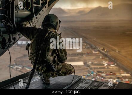 Un soldato degli Stati Uniti assegnato alla X Divisione montagna effettua indagini sulla parte posteriore di un CH-47 Chinook durante il volo sopra la regione meridionale di Kabul, Afghanistan il 6 novembre 2019. (STATI UNITI Foto della riserva dell'esercito da SPC. Jeffery J. Harris/ rilasciato) Foto Stock