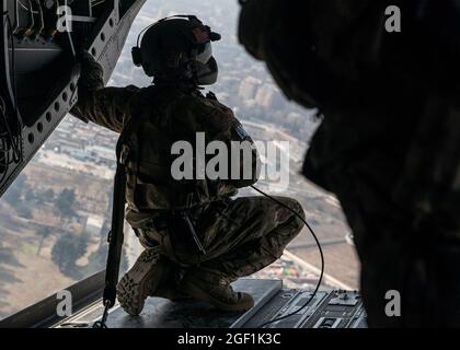 Un soldato degli Stati Uniti assegnato alla X Divisione montagna effettua indagini sul paesaggio dalla parte posteriore di un CH-47 Chinook durante il volo sopra Kabul, Afghanistan il 27 novembre 2019. (STATI UNITI Foto della riserva dell'esercito da SPC. Jeffery J. Harris/ rilasciato) Foto Stock