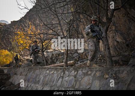 Il personale dell'esercito degli Stati Uniti Sgt. Bryan Jones, del Queens, N.Y., e i compagni soldati assegnati a Combat Company, 1° Battaglione, 32° Regiment fanteria, 3° Team di combattimento Brigata, 10° Divisione montagna, camminano lungo la Valle di Shigal verso il villaggio di Lachey nel distretto di Shigal della provincia di Kunar, Afghanistan il 7 dicembre. Foto Stock