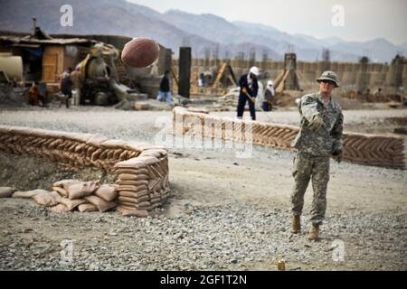 SPC dell'esercito degli Stati Uniti. Robert Sumner, 31 anni, da Birmingham, Inghilterra, gioca a calcio prima di uscire in missione dalla base operativa di avanzamento Joyce, Afghanistan, 12 dicembre 2009. Sumner è assegnato alla sicurezza personale distaccamento, sede e Headquares Company, 1 ° battaglione, 32 ° reggimento fanteria, 3 ° Brigade Combat Team, 10 ° Divisione montagna. Foto Stock