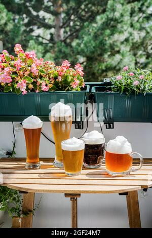 Diversi tipi di birra in bicchieri su tavola di legno Foto Stock