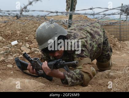 Un tirocinante di base dell'esercito nazionale afghano striscia sotto il filo spinato mentre negozia un corso di ostacolo al Centro di addestramento militare regionale di Gardez nella provincia di Paktya, Afghanistan, 25 febbraio 2013. Il tirocinante sta partecipando a un corso di formazione di base di nove settimane, che si laureerà a marzo circa 600 nuovi soldati ANA. (STATI UNITI Esercito foto di SPC. Tianna Waite/rilasciato) Foto Stock