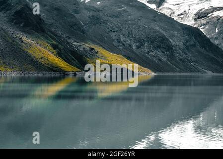 Bella riflessione in un serbatoio d'acqua nelle montagne austriache. Foto Stock
