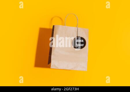 Sacchetto di carta con bauble nero opaco con scritta venerdì nera su sfondo giallo Foto Stock