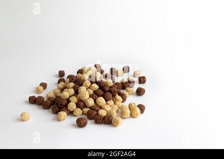 colazione al cioccolato e alla vaniglia, cereali, mucchio di palle di cereali, palle di mais al cioccolato, vista laterale Foto Stock