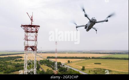 Il drone sorvola le torri di telecomunicazione in campagna Foto Stock
