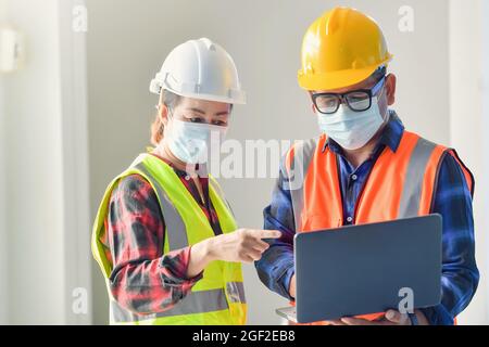 Ingegnere civile che lavora con un computer portatile presso la scrivania del cantiere. Foto Stock