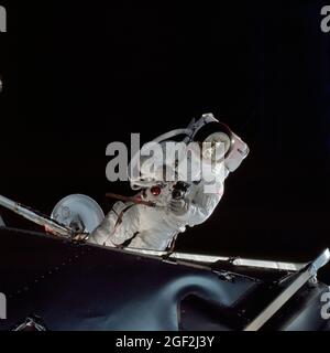 L'astronauta Russell L. Schweickart, pilota a modulo lunare, gestisce una macchina fotografica Hasselblad da 70 mm durante la sua attività straveicolare il quarto giorno della missione orbitale terrestre Apollo 9. Il modulo di comando/assistenza e il modulo Lunar 3 'Spider' sono ancorati. Questa vista è stata presa dal modulo di comando 'Gumdrop'. Schweickart, che indossa una Extravehicular Mobility Unit (EMU), è in piedi in 'pantofole dorate' sul portico Lunar Module. Sul retro, parzialmente visibili, sono presenti un sistema di supporto della vita portatile (PLSS) e un sistema di spurgo dell'ossigeno (OPS). Foto Stock