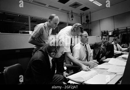 (14 aprile 1970) --- diverse persone importanti per la missione Apollo 13, presso le console della Sala di controllo delle operazioni della Missione (MOCR) del Centro di controllo della Missione (MCC). Seduti alle console, da sinistra a destra, ci sono gli astronauti Donald K. Slayton, direttore delle operazioni dell'equipaggio di volo; l'astronauta Jack R. Lousma, il comunicatore della navicella spaziale Shift 3; e l'astronauta John W. Young, comandante dell'equipaggio di riserva Apollo 13. In piedi, da sinistra a destra, sono l'astronauta Tom K. Mattingly II, che è stato sostituito come Apollo 13 modulo di comando pilota dopo che è stato imparato che può scendere con morbillo, e astronauta Vance D. Brand, SH Foto Stock