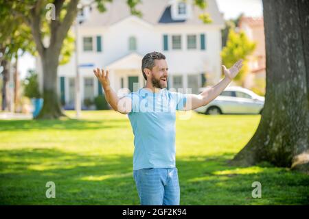 felice uomo maturo in piedi all'aperto a casa, successo Foto Stock