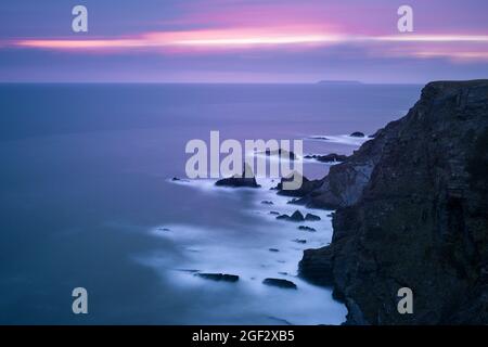 La costa frastagliata di Hartland Quay dalla cima di Warren Cliff sul North Devon Coast National Landscape con Lundy Island all'orizzonte, in Inghilterra. Foto Stock
