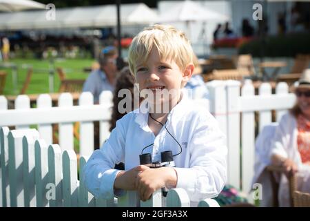 Egham, Surrey, Regno Unito. 22 agosto 2021. Un giovane fan di polo prende in prestito il binocolo di papà. Credit: Maureen McLean/Alamy Foto Stock