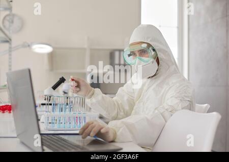 Lo scienziato in laboratorio conduce una seria ricerca chimica che lavora con campioni biologici. Foto Stock