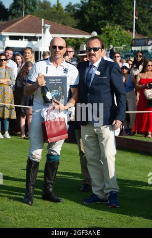 Egham, Surrey, Regno Unito. 22 agosto 2021. Il giocatore di polo Alassandro Bazzoni riceve il suo regalo Cartier e lo champagne da John Collins CEO e fondatore di Talacrest dopo aver giocato nella finale della Coppa del Campionato del Principe di Galles di Talacrest al Guards Polo Club. Credit: Maureen McLean/Alamy Foto Stock