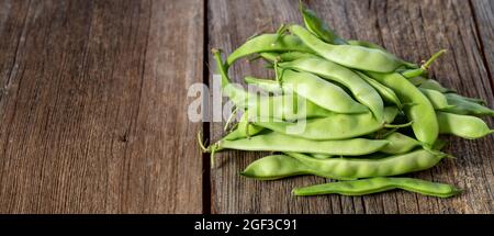 fagioli verdi freschi maturi su sfondo di legno Foto Stock